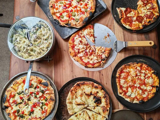 Un tavolo visto dall'alto con diverse pizze e contorni