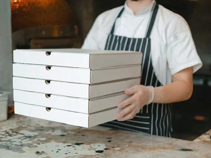Una pila di scatole per la pizza portata a braccio